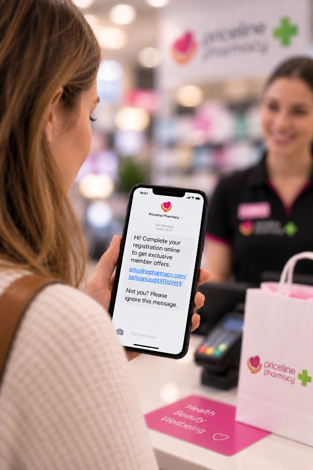 Customer reading a membership registration SMS on her phone at a Priceline Pharmacy checkout